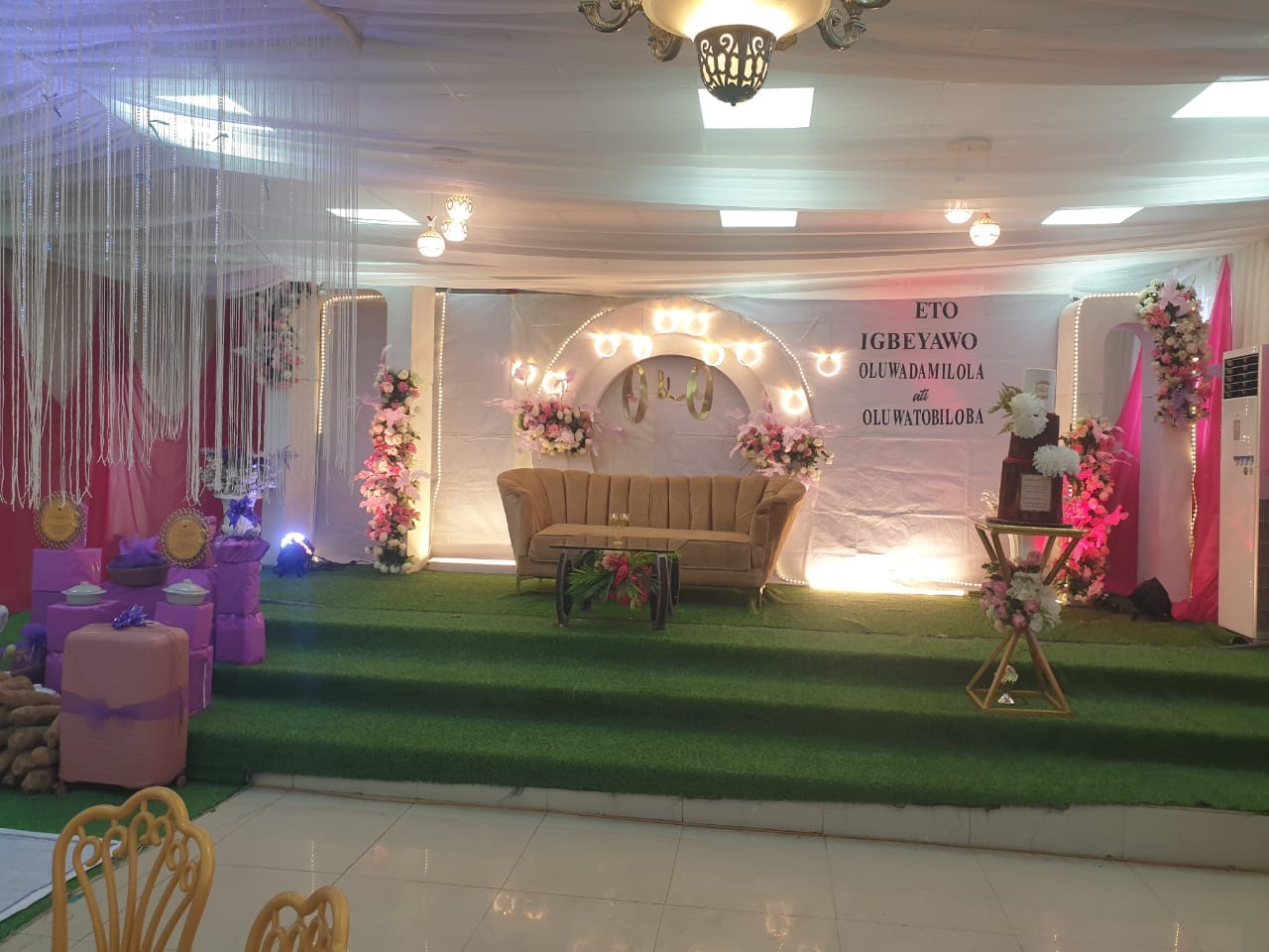 Decorated celebration stage with a sofa and floral arrangements